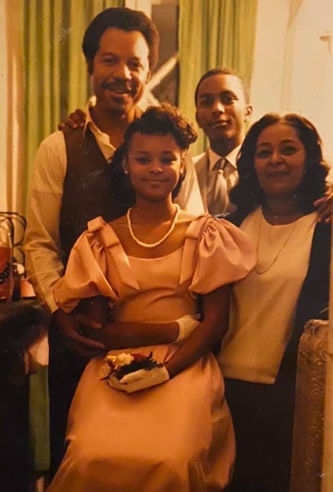 Sonya in a peach dress and pearls, surrounded by family