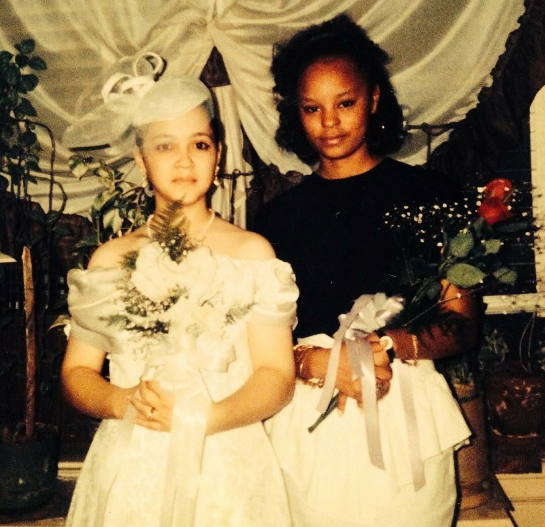 Sonya holding roses beside a bride at a wedding